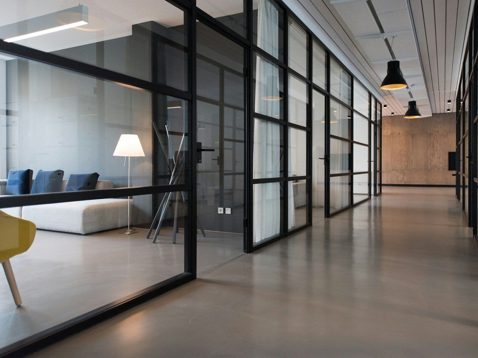 A bright office corridor with glass partitions